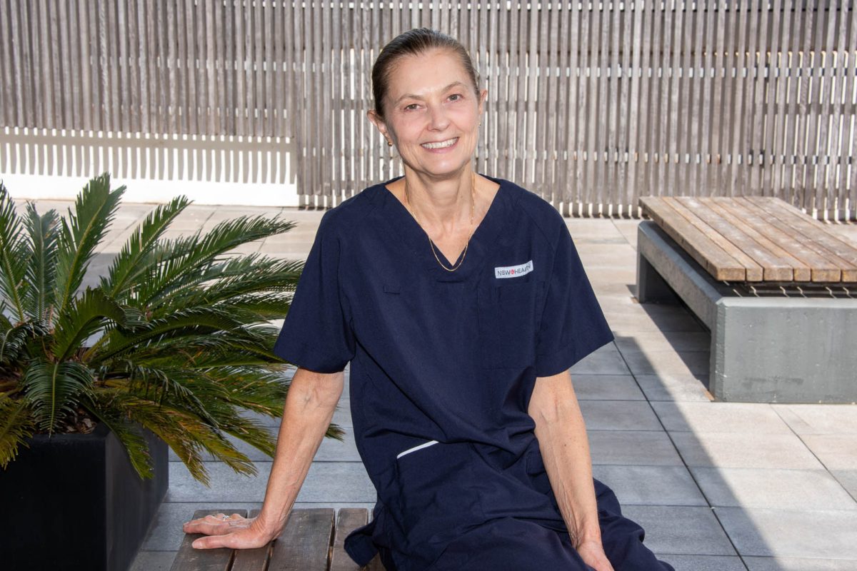 Woman in nurse uniform sitting on a bench looking relaxed and happy