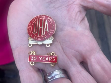 a badge on a hand. words read UHA 30 years