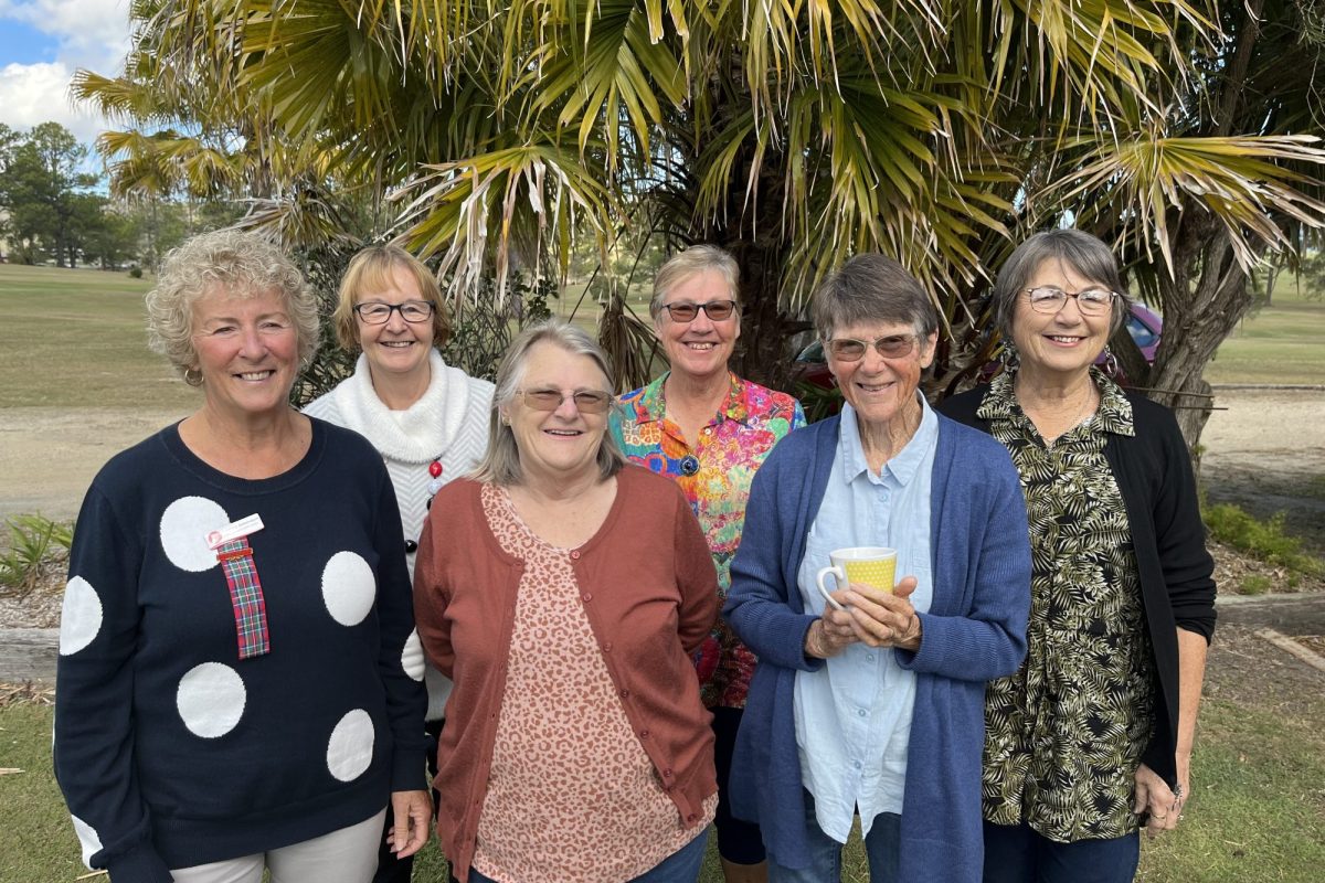 Six women standing together, three at the back and three at the front.