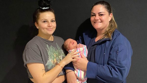 Two women holding a newborn baby