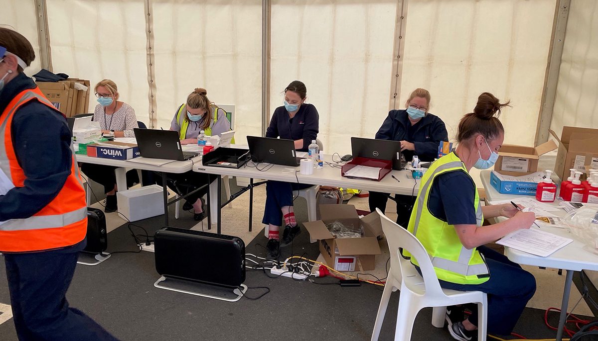 health workers recording information in a temporary clinic