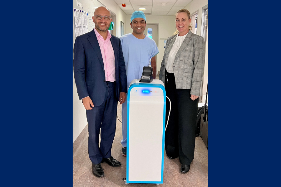 Three medical professionals standing with a new piece of technology.