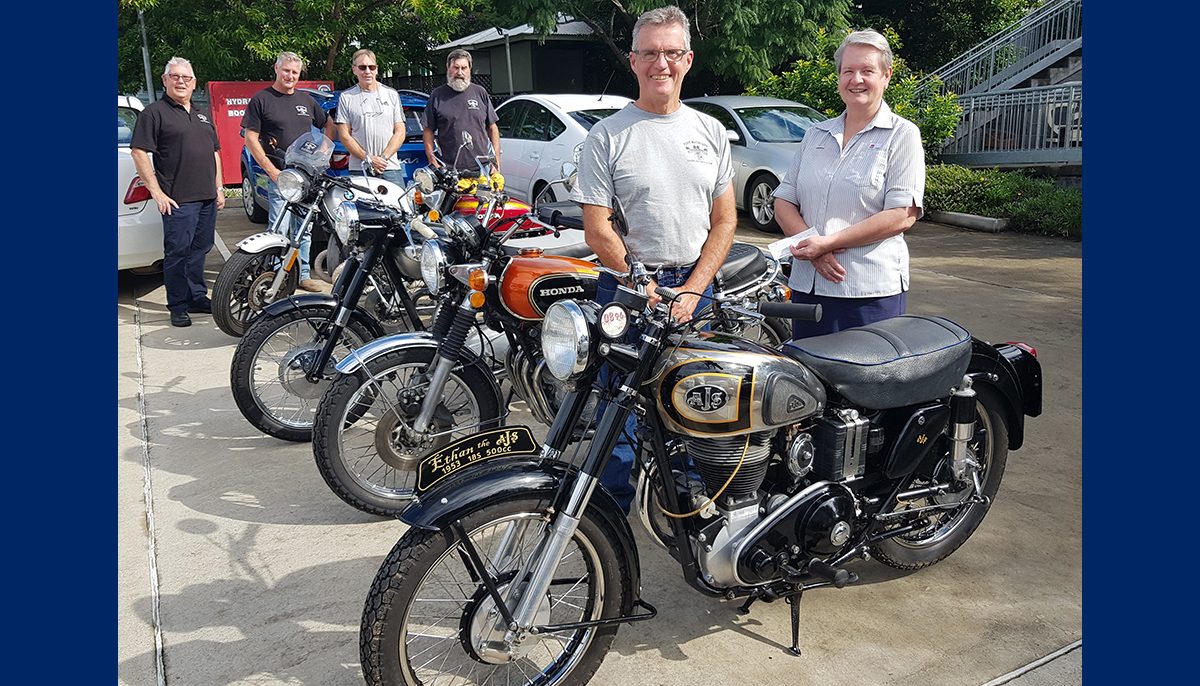 two people in foreground with five motorbikes. in the background are four more people