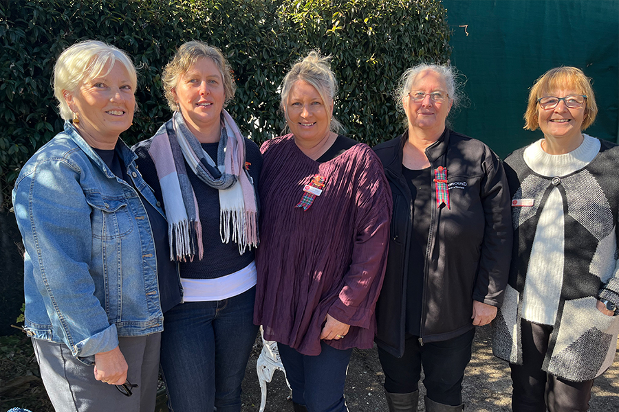 Five ladies standing side by side and smiling