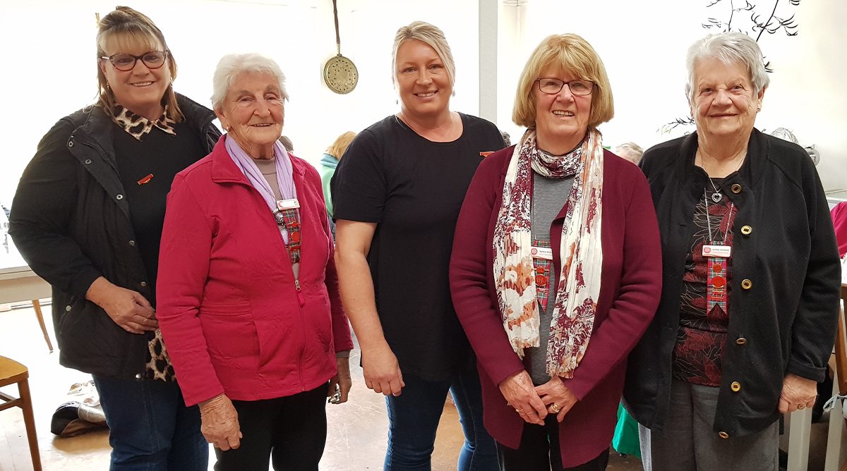 five women standing side by side