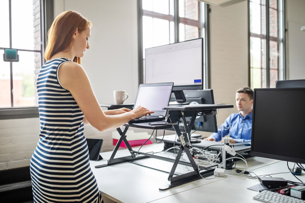 A businesswoman working at an ergonomic standing desk
