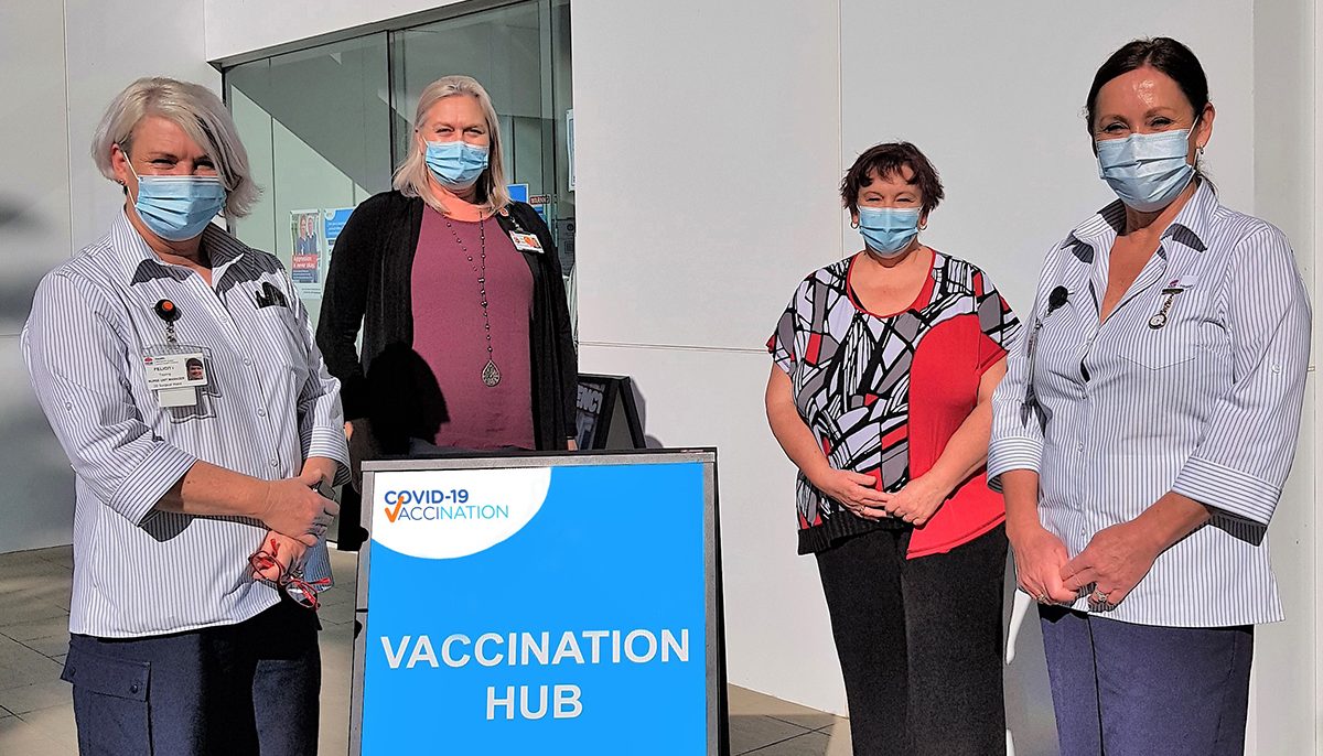 four women standing at entrance to vaccination clinic