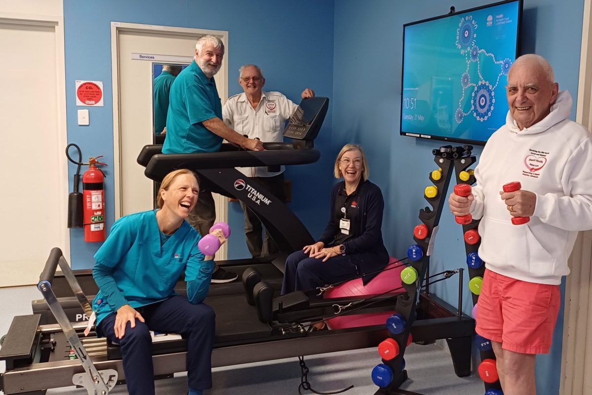 five people in a gym. Three older men on equipment, a nurse and physiotherapist.