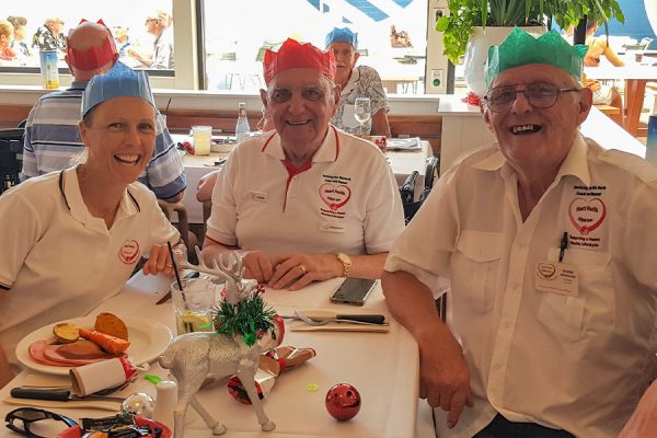 three people wearing paper Christmas hats
