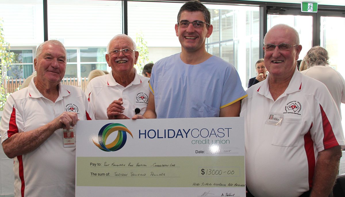 three men present big cheque to doctor