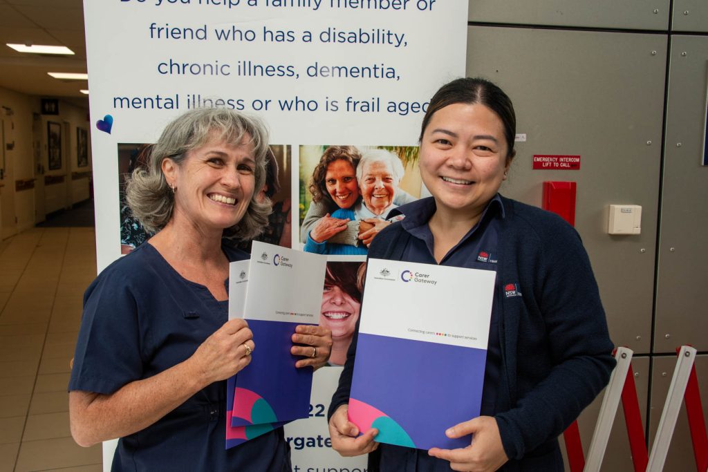 Two healthcare workers with an aged care display.