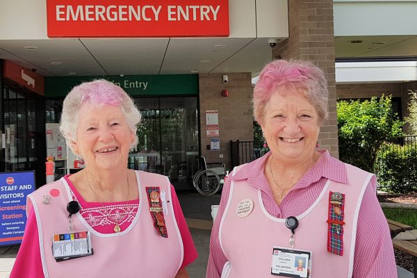 two women in pink smocks outside hospital