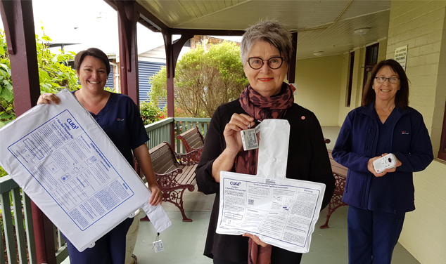 Nurses and volunteer holding hospital equipment