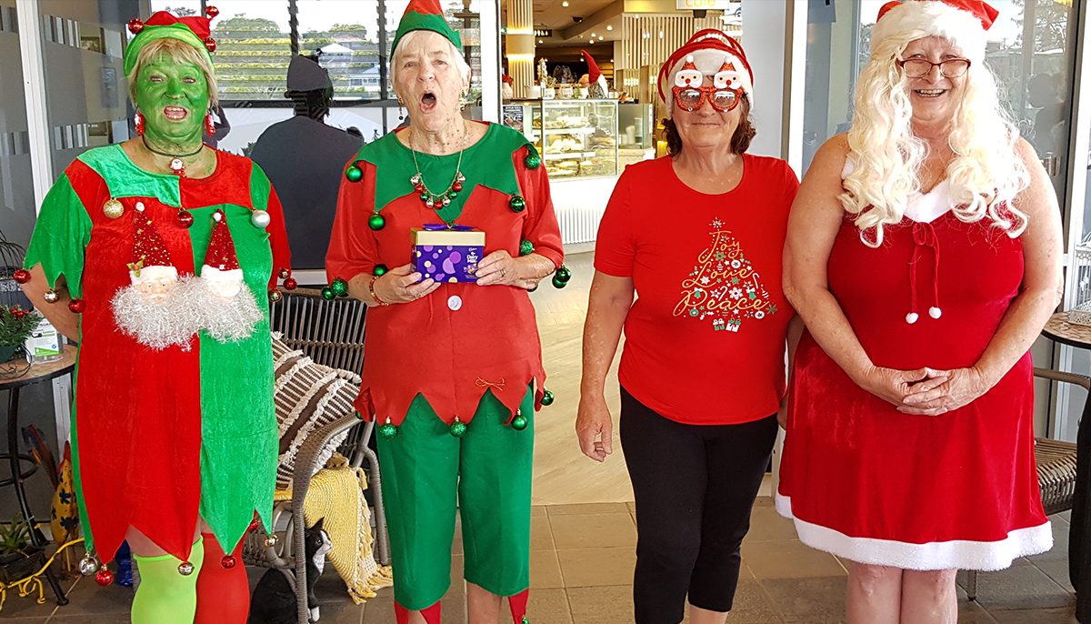 four women dressed in Christmas outfits