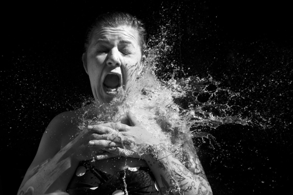 Woman reacting to being hit with a water bomb.