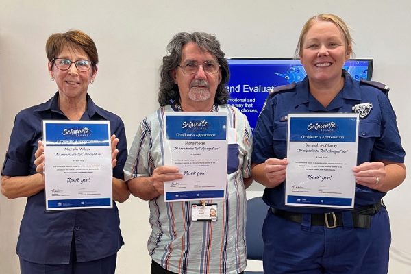 three people holding certificates.