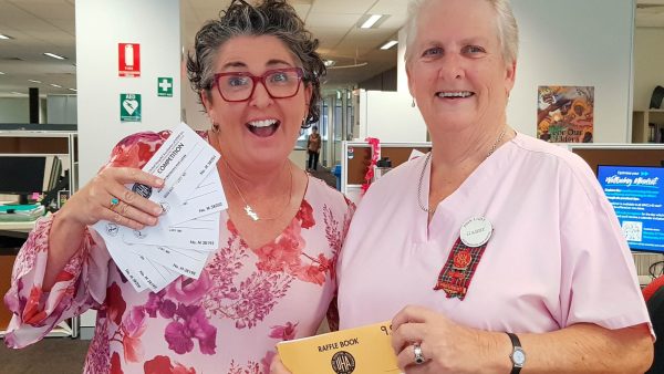 Two women looking excited about raffle tickets.