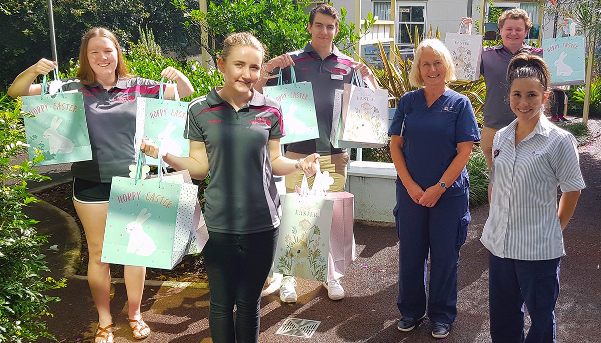 people in a garden holding hampers