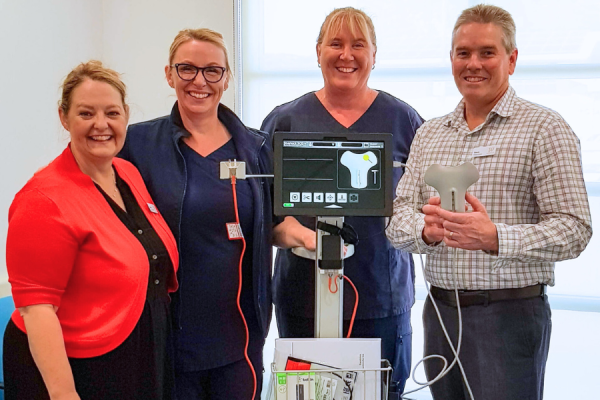 Health staff and donors with a new piece of equipment for cancer patients.