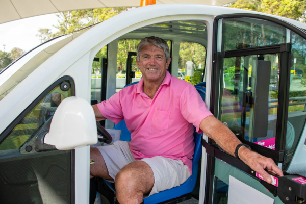 Man in a pink shirt inside an electric vehicle