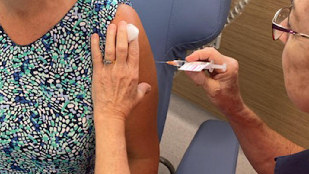 Close up photograph of vaccine needle going into arm