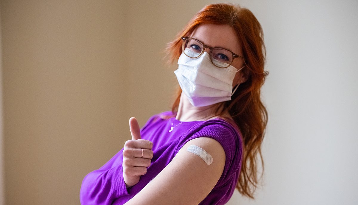 Woman with thumbs up after COVID-19 vaccination