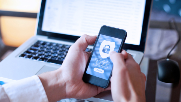 Man holding mobile phone looking at login screen with padlock icon.